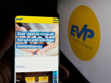 Stuttgart, Almanya - 07-30-2025: Logo önündeki ekranda Evangelische Volkspartei der Schweiz 'in (EVP) web sayfası bulunan kişi. Telefon ekranının merkezine odaklan.