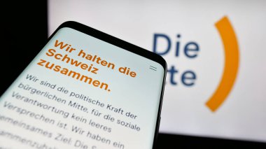 Stuttgart, Almanya - 07-30-2025: İsviçreli siyasi parti Die Mitte 'nin web sitesi logonun önünde ekranda. Telefon ekranının sol üst kısmına odaklan.