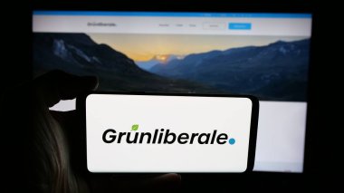 Stuttgart, Almanya - 07-30-2025: Cep telefonunda İsviçreli Grunliberale Partei Schweiz (GLP) logosu olan kişi web sayfası önünde ekranda. Telefon ekranına odaklan.
