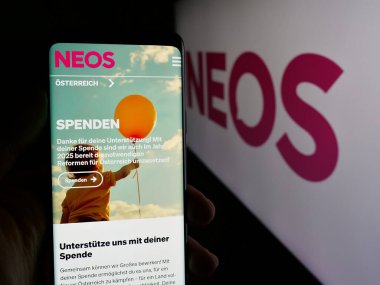Stuttgart, Almanya - 08-01-2025: Logo önünde ekranda NEOS Das Neue Oesterreich und Liberales Forum web sayfası bulunan kişi. Telefon ekranının merkezine odaklan.