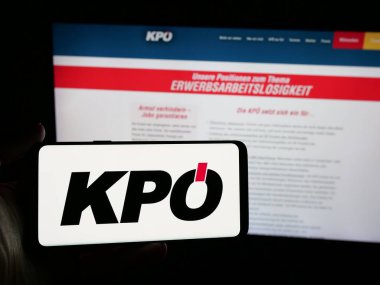 Stuttgart, Almanya - 08-01-2025: İnternet sitesi önünde üzerinde parti Kommunistische Partei Oesterreichs (KPO) logosu bulunan kişi. Telefon ekranına odaklan.