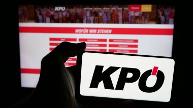 Stuttgart, Almanya - 08-01-2025: İnternet sayfası önünde üzerinde parti Kommunistische Partei Oesterreichs (KPOe) logosu bulunan cep telefonu sahibi kişi. Telefon ekranına odaklan.