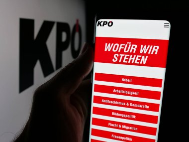 Stuttgart, Almanya - 08-01-2025: Parti Kommunistische Partei Oesterreichs 'in (KPOe) web sayfası logonun önünde duran kişi. Telefon ekranının merkezine odaklan.