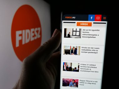 Stuttgart, Almanya - 08-01-2025: Parti Fidesz - Magyar Polgari Szovetseg adlı web sitesi logonun önünde duran kişi. Telefon ekranının merkezine odaklan.