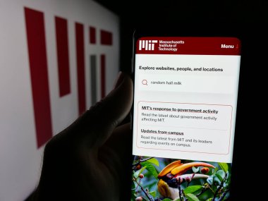 Stuttgart, Almanya - 08-01-2025: Massachusetts Teknoloji Enstitüsü (MIT) internet sayfası logonun önünde cep telefonu tutan kişi. Telefon ekranının merkezine odaklan.