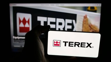 Stuttgart, Almanya - 08-07-2025: Web sayfasının önünde ekranda ABD 'li makine şirketi Terex Corporation' ın logosuyla cep telefonu tutan kişi. Telefon ekranına odaklan.