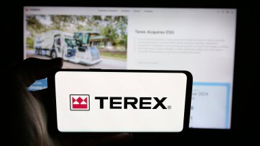 Stuttgart, Almanya - 08-07-2025: Web sayfasının önünde ekranda ABD 'li makine şirketi Terex Corporation' ın logosuyla cep telefonu tutan kişi. Telefon ekranına odaklan.