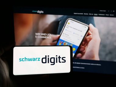 Stuttgart, Almanya - 08-07-2025: Alman bilişim şirketi Schwarz Digits KG 'nin logosunu elinde tutan kişi web sitesinin önünde ekranda. Telefon ekranına odaklan.