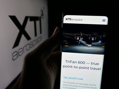 Stuttgart, Almanya - 08-14-2025: ABD 'li VTOL şirketi XTI Aerospace Inc.' in web sayfası olan kişi logonun önünde ekranda. Telefon ekranının merkezine odaklan.