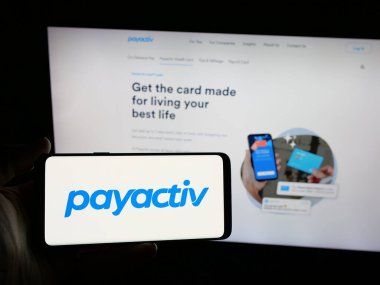 Stuttgart, Almanya - 08-14-2025: ABD 'li fintech şirketi Payactiv Inc.' in logosunu elinde tutan kişi web sitesinin önünde ekranda. Telefon ekranına odaklan.
