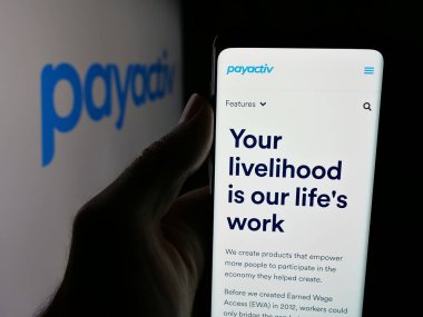 Stuttgart, Almanya - 08-14-2025: ABD 'li fintech şirketi Payactiv Inc.' in web sayfası ile akıllı telefon sahibi kişi logonun önünde ekranda. Telefon ekranının merkezine odaklan.