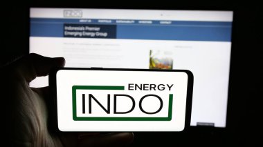 Stuttgart, Almanya - 08-14-2025: İnternet sayfası önünde Endonezya Enerji Şirketi 'nin (Indo) logosunun bulunduğu cep telefonu sahibi kişi. Telefon ekranına odaklan.