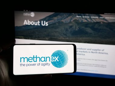 Stuttgart, Almanya - 08-14-2025: Metanol şirketi Methanex Corporation 'ın logosunu elinde tutan kişi web sitesinin önünde ekranda. Telefon ekranına odaklan.