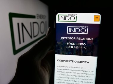 Stuttgart, Almanya - 08-14-2025: Logo önünde Endonezya Enerji Şirketi 'nin (Indo) web sayfası olan akıllı telefonu elinde tutan kişi. Telefon ekranının merkezine odaklan.