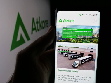 Stuttgart, Almanya - 08-14-2025: ABD 'li elektrik şirketi Atkore Inc.' in web sayfası ile akıllı telefon sahibi kişi logonun önünde ekranda. Telefon ekranının merkezine odaklan.