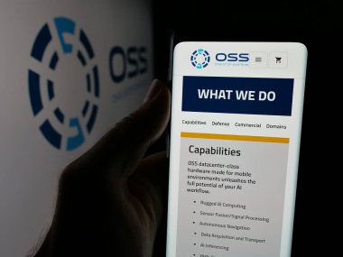 Stuttgart, Almanya - 08-14-2025: ABD 'li One Stop Systems Inc. (OSS) şirketinin web sayfası logonun önünde duran kişi. Telefon ekranının merkezine odaklan.