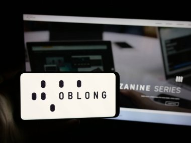 Stuttgart, Almanya - 08-15-2025: ABD 'li işbirliği platformu şirketi Oblong Inc.' in logosunu elinde tutan kişi web sitesinin önünde ekranda. Telefon ekranına odaklan.
