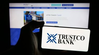 Stuttgart, Almanya - 08-18-2025: ABD 'li finans şirketi Trustco Bank' ın logosunun bulunduğu cep telefonu web sayfası önünde ekranda. Telefon ekranına odaklan.