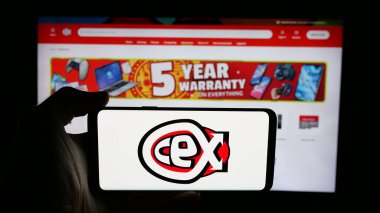 Stuttgart, Almanya - 08-18-2025: İngiliz perakende şirketi C.E.X. logosu olan kişi. Web sayfasının önündeki ekranda sınırlı (CeX). Telefon ekranına odaklan.