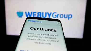 Stuttgart, Almanya - 08-18-2025: E-ticaret şirketi Webuy Global Ltd. 'nin web sitesiyle birlikte cep telefonu logonun önünde ekranda. Telefon ekranının sol üst kısmına odaklan.