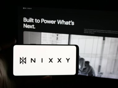 Stuttgart, Almanya - 08-18-2025: İnternet sitesinin önünde ekranda ABD 'li iletişim şirketi Nixxy Inc.' in logosuna sahip akıllı telefonu tutan kişi. Telefon ekranına odaklan.