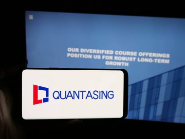 Stuttgart, Almanya - 08-18-2025: Çinli şirket QuantaSing Group Limited 'in logosuna sahip akıllı telefon sahibi kişi web sitesinin önünde ekranda. Telefon ekranına odaklan.