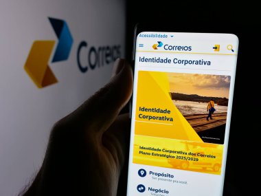 Stuttgart, Almanya - 08-19-2025: Logonun önündeki ekranda Empresa Brasileira de Correios e Telegrafos 'un web sayfası bulunan kişi. Telefon ekranının merkezine odaklan.