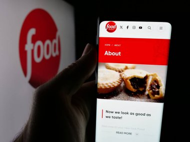 Stuttgart, Almanya - 08-20-2025: ABD kablolu televizyon kanalı Food Network 'ün web sayfası olan akıllı telefon sahibi kişi logonun önünde ekranda. Telefon ekranının merkezine odaklan.