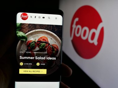 Stuttgart, Almanya - 08-20-2025: ABD kablolu televizyon kanalı Food Network 'ün internet sayfası olan cep telefonu logonun önünde ekranda. Telefon ekranının merkezine odaklan.