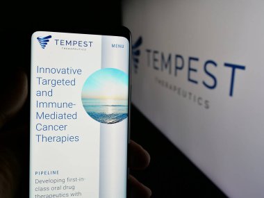 Stuttgart, Almanya - 08-20-2025: ABD 'li biyoteknoloji şirketi Tempest Therapeutics Inc.' in web sayfası ile akıllı telefon sahibi kişi logonun önünde ekranda. Telefon ekranının merkezine odaklan.
