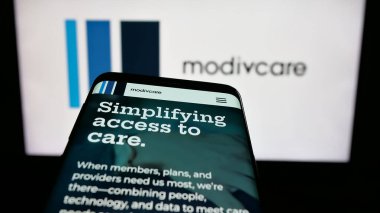 Stuttgart, Almanya - 08-20-2025: ABD 'li sağlık şirketi Modivcare Inc.' in web sitesi logo önünde ekranda. Telefon ekranının sol üst kısmına odaklan.