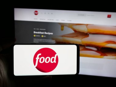 Stuttgart, Almanya - 08-20-2025: ABD kablolu televizyon kanalı Food Network 'ün logosunu taşıyan kişi web sitesinin önünde ekranda. Telefon ekranına odaklan.