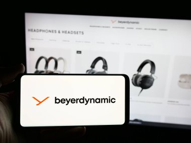 Stuttgart, Almanya - 08-20-2025: Alman şirketinin beyerdynamic GmbH Co. KG logosuna sahip akıllı telefon sahibi kişi web sitesi önünde ekranda. Telefon ekranına odaklan.
