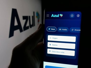 Stuttgart, Almanya - 08-21-2025: Havayolu Azul Linhas Aereas Brasileiras 'ın web sayfası logonun önünde bulunan kişi. Telefon ekranının merkezine odaklan.