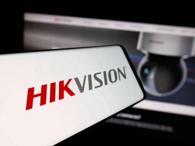 Stuttgart, Almanya - 08-22-2025: İnternet sitesinin önünde ekranda Hangzhou Hikvision Dijital Teknoloji logosu olan akıllı telefon. Telefon ekranının merkez soluna odaklan.