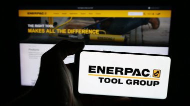 Stuttgart, Almanya - 08-22-2025: Web sayfasının önünde ekranda ABD 'li araç şirketi Enerpac Tool Group Corp.' un logosunu taşıyan cep telefonu sahibi kişi. Telefon ekranına odaklan.