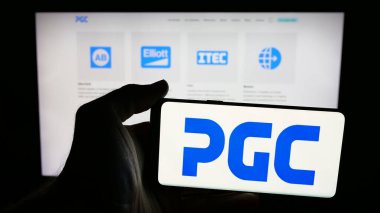 Stuttgart, Almanya - 08-22-2025: Web sayfası önünde ekranda ABD 'li Power Grid Components Inc. (PGC) şirketinin logosunun bulunduğu cep telefonu sahibi kişi. Telefon ekranına odaklan.