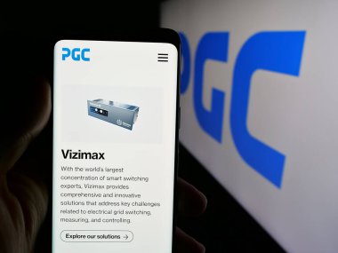 Stuttgart, Almanya - 08-22-2025: Logo önünde ekranda ABD 'li Power Grid Components Inc. (PGC) şirketinin web sayfası bulunan cep telefonu. Telefon ekranının merkezine odaklan.