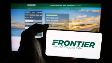 Stuttgart, Almanya - 08-22-2025: ABD 'li havayolu şirketi Frontier Airlines' ın logosunun bulunduğu cep telefonu web sayfası önünde ekranda. Telefon ekranına odaklan.
