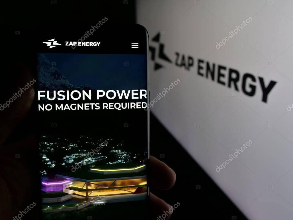 Stuttgart, Germany - 08-21-2025: Person holding cellphone with webpage of US fusion power company Zap Energy Inc. on screen in front of logo. Focus on center of phone display.