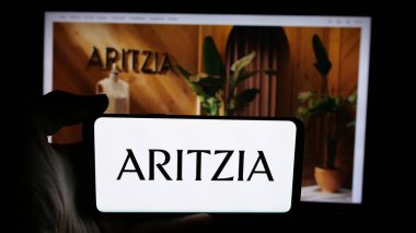 Stuttgart, Almanya - 08-22-2025: Kanadalı giyim perakende şirketi Aritzia LP 'nin logosunu taşıyan cep telefonu web sayfasının önünde. Telefon ekranına odaklan.