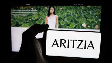 Stuttgart, Almanya - 08-22-2025: Kanadalı giyim perakende şirketi Aritzia LP 'nin logosunu taşıyan cep telefonu web sitesinin önünde. Telefon ekranına odaklan.