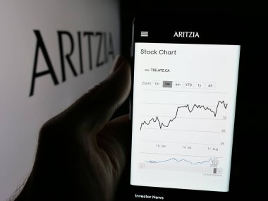 Stuttgart, Almanya - 08-22-2025: Kanadalı giyim perakende şirketi Aritzia LP 'nin internet sayfası ile cep telefonu tutan kişi logonun önünde ekranda. Telefon ekranının merkezine odaklan.