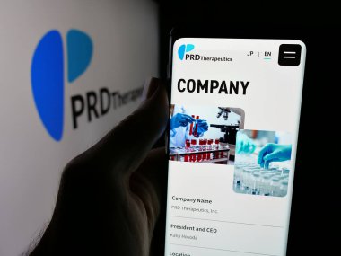 Stuttgart, Almanya - 08-22-2025: Biyoteknoloji şirketi PRD Therapeutics Inc. 'in web sayfasını elinde tutan kişi logonun önünde ekranda. Telefon ekranının merkezine odaklan.