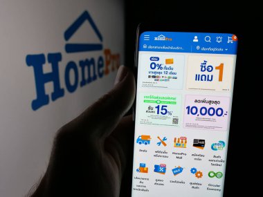 Stuttgart, Almanya - 08-25-2025: Tayland ev geliştirme perakende şirketi HomePro 'nun web sayfası ile akıllı telefon sahibi kişi logonun önünde ekranda. Telefon ekranının merkezine odaklan.
