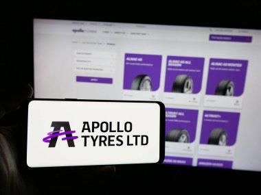 Stuttgart, Almanya - 08-25-2025: Hint lastik şirketi Apollo Lastik Limited 'in logosuna sahip akıllı telefon sahibi kişi web sitesinin önünde ekranda. Telefon ekranına odaklan.