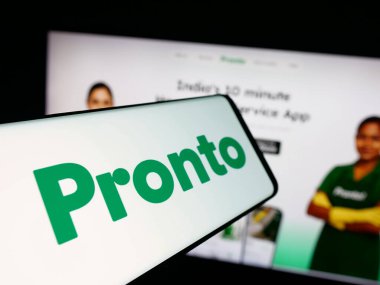 Stuttgart, Almanya - 09-26-2025: Hintli ev uygulaması uygulaması logosu olan akıllı telefon web sitesinin önünde ekranda. Telefon ekranının merkez soluna odaklan.