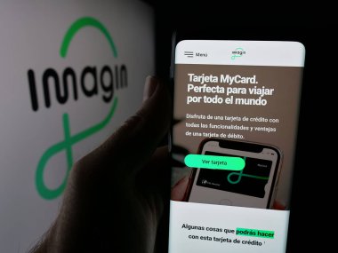Stuttgart, Almanya - 09-26-2025: Logo önünde ekranda İspanyol bankasının imajinersGen S.A. (Imagin) web sayfası bulunan akıllı telefon sahibi kişi. Telefon ekranının merkezine odaklan.
