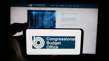 Stuttgart, Almanya - 09-26-2025: ABD kuruluşu Kongre Bütçe Ofisi 'nin (CBO) logosunun bulunduğu cep telefonu web sayfası önünde ekranda. Telefon ekranına odaklan.