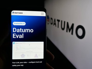 Stuttgart, Almanya - 09-27-2025: Koreli AI şirketi Datumo Inc. 'nin web sayfası ile logo önünde cep telefonu tutan kişi. Telefon ekranının merkezine odaklan.